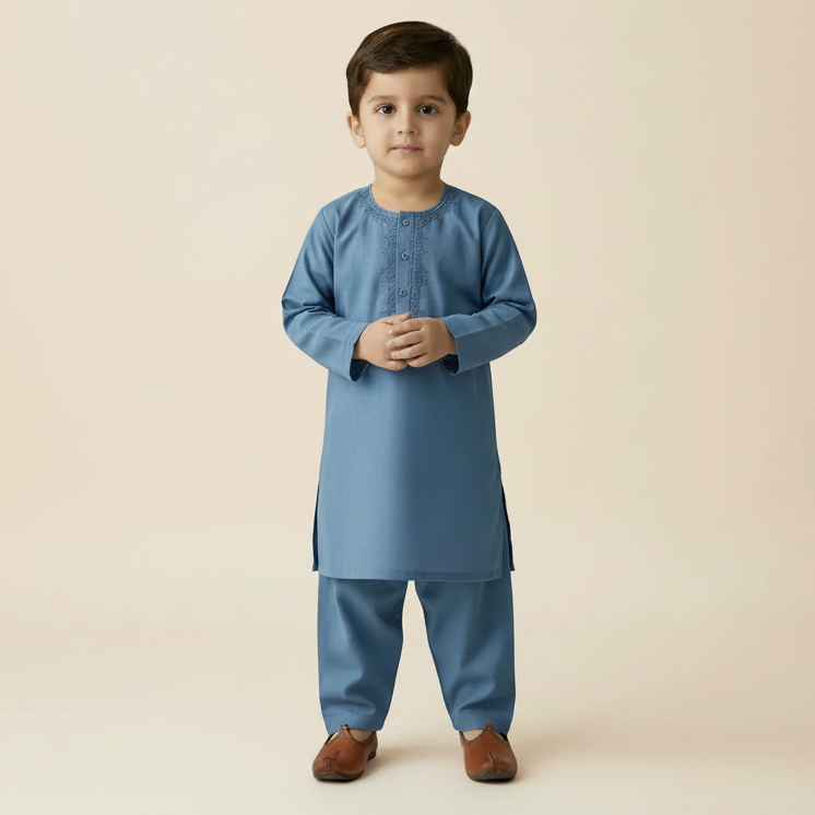 Young boy wearing a blue traditional outfit on a beige background
