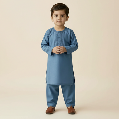 Young boy wearing a blue traditional outfit on a beige background