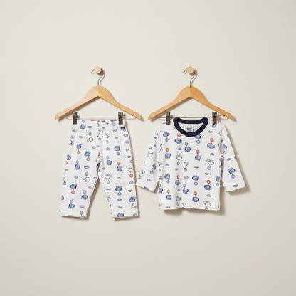 Children's pajama set with long-sleeve shirt and pants on hangers against a beige background