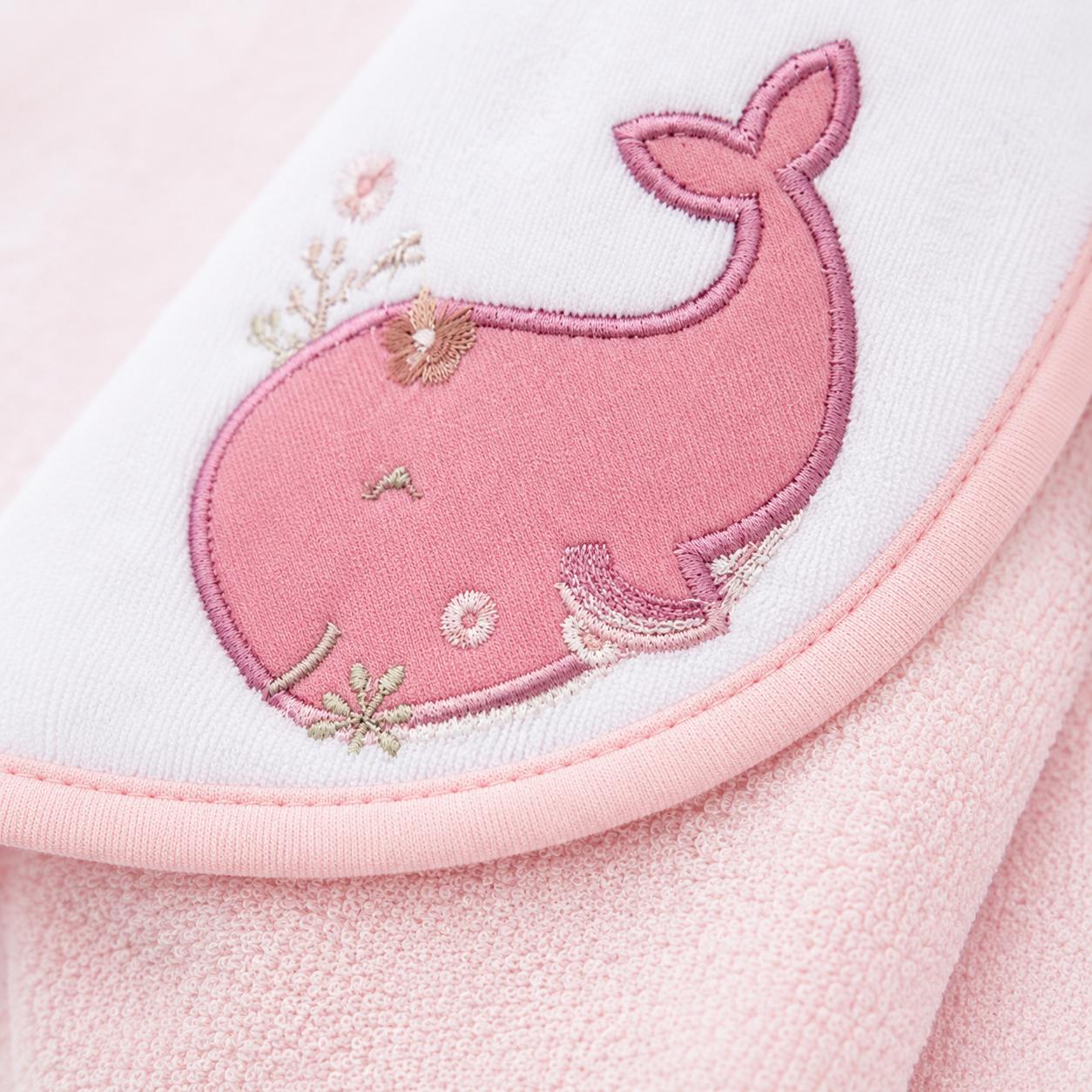 Close up of embroidered pink whale detail on baby hooded towel