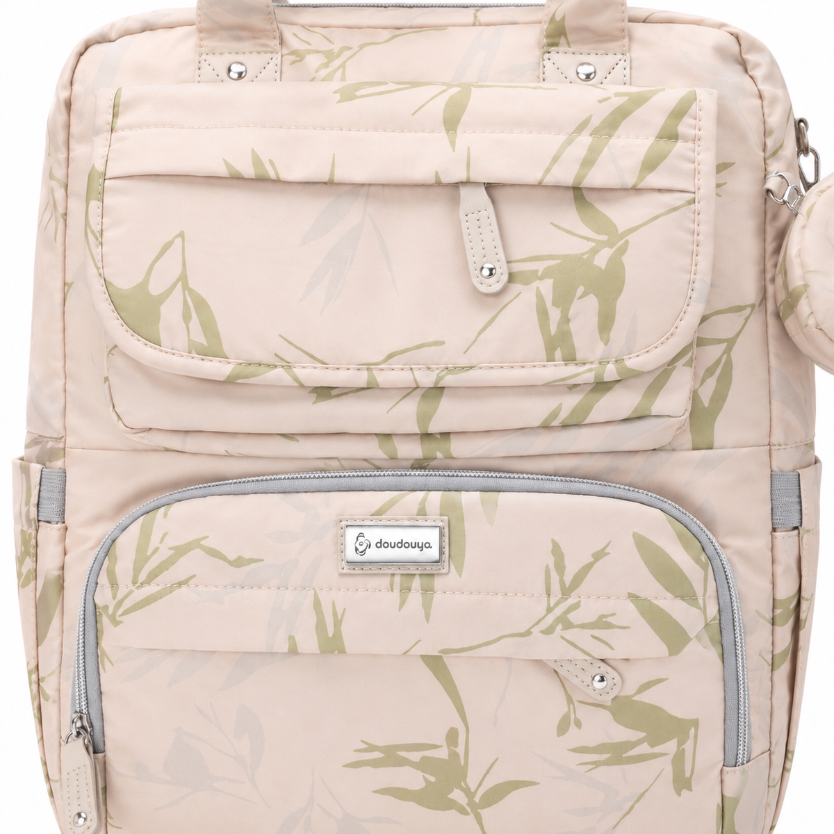 Beige botanical print mother and baby diaper backpack close-up showing front pockets, stitching and zipper detail