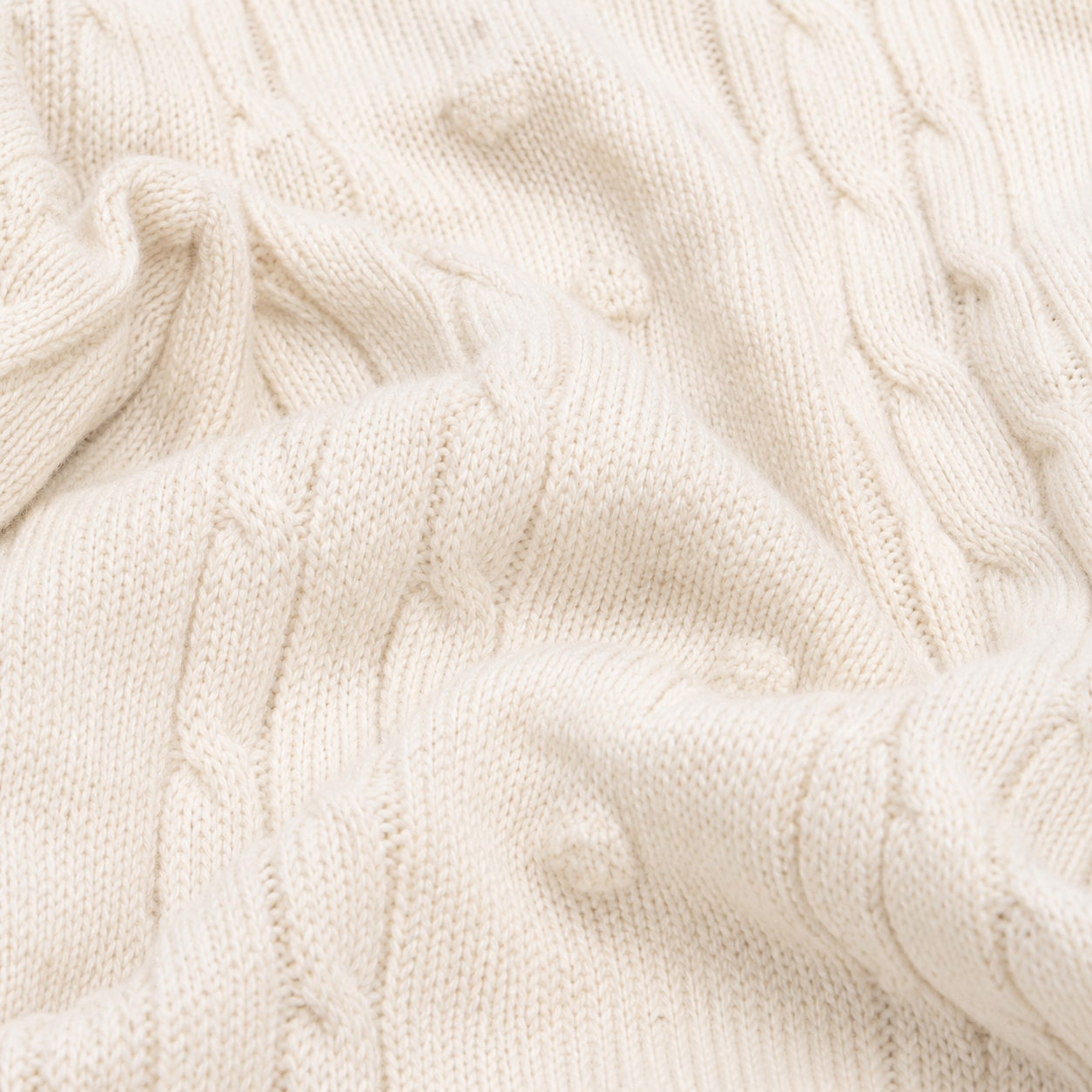 Ivory cable knit baby romper fabric texture close-up