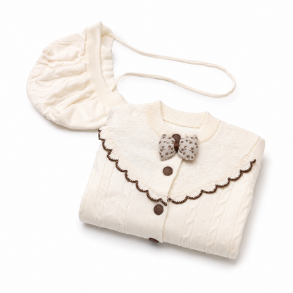 Ivory cable knit baby romper set folded presentation view with matching bonnet