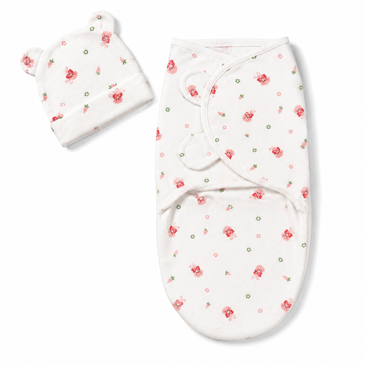 Newborn baby swaddle wrap and matching cap pink bunny print flat lay product photo